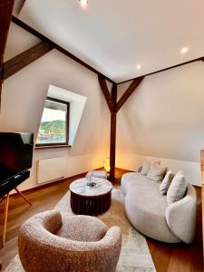 a living room with a couch and a tv at Hotel Villa Vie Cochem in Cochem