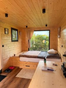 a bedroom in a log cabin with a bed and a window at Maringotka na kopečku in Kotaneč