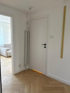 a room with a white door and a wooden floor at Apartament Opoczno in Opoczno