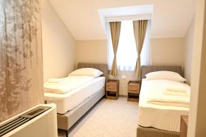 ein Hotelzimmer mit zwei Betten und einem Fenster in der Unterkunft Hotel Unca in Jajce