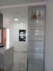 a kitchen with a glass door with wine glasses at Cabouqueiro's House in Mateuzinho