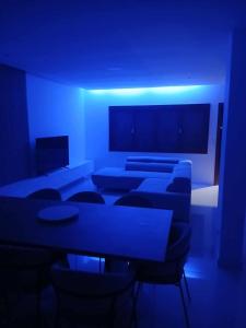 a blue room with couches and tables and chairs at Cabouqueiro's House in Mateuzinho