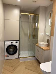 a bathroom with a shower and a washing machine at Apartament Opoczno in Opoczno