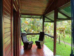 two chairs sitting on the porch of a house at Cabañas Los Laguitos Rio Celeste in El Achiote
