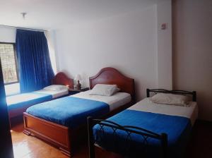 two beds in a small room with a window at Hotel Rivera Plaza in Cali +22 photos