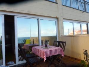 Ein Tisch und Stühle auf einem Balkon mit Blick auf das Meer in der Unterkunft CASAS MARE , Ponta Delgada, Madeira in Ponta Delgada