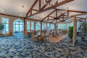 a dining room with tables and chairs and windows at Isaiah Tubbs Resort & Conference Centre in Picton