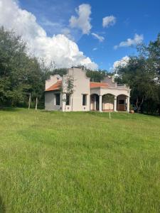 a house in a field with a grassy yard at Casa Tala in Villa Las Rosas