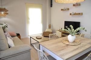 a living room with a table with a vase of flowers on it at Casa El Abuelo in Bronchales