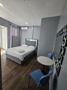 a bedroom with a bed and a table and chairs at Hotel Residencial La Malvarrosa in Panama City