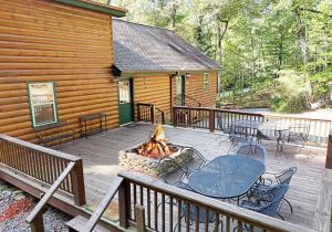 a deck with a fireplace and a table and chairs at S'more Waggin' Cabin: Pet-Friendly--wifi, firepit, pool table in Blue Ridge