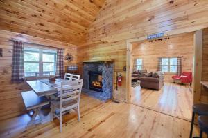 a living room with a fireplace in a log cabin at S'more Waggin' Cabin: Pet-Friendly--wifi, firepit, pool table in Blue Ridge