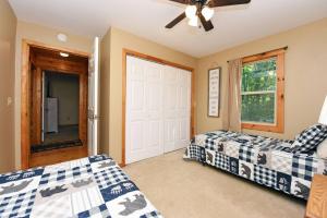 a bedroom with two beds and a door at S'more Waggin' Cabin: Pet-Friendly--wifi, firepit, pool table in Blue Ridge