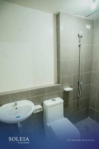 a bathroom with a toilet and a sink and a shower at Linear Space at Soleia Butuan Unit G in Butuan +10 photos