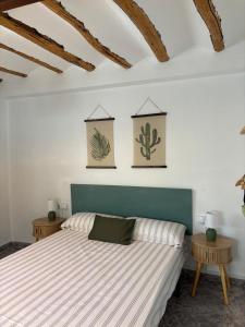 a bedroom with a bed with two pictures on the wall at El Rincón de Laura - Quesada in Quesada
