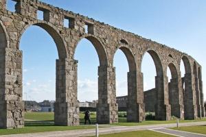 a large stone bridge with arches on a field at Studio Praia & Sol De Verão in Vila do Conde