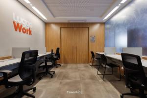 a conference room with tables and chairs and a door at Luggo Inter Residence - Região Central BH in Belo Horizonte