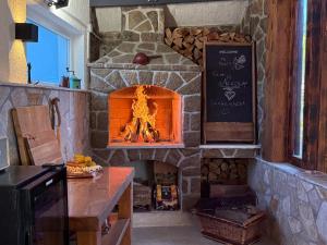 a kitchen with a stone fireplace in a kitchen at Kuća Koza-Apartment Marijana in Punat