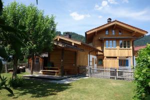a wooden house with a fence in front of it at Beim Schlenz in Reit im Winkl
