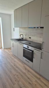 a kitchen with white cabinets and a stove at Hof am Berg in Kaunerberg