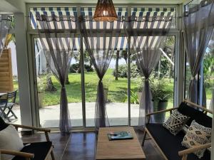 a living room with a large window with curtains at Appartement bord de mer in Montjoly