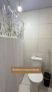 a bathroom with a toilet and a shower curtain at Casaraosete7 in Salvador +4 photos