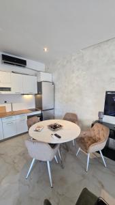 a kitchen with a table and chairs in a room at CANj LOUNGE STUDIO in Čanj
