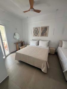 a bedroom with a large bed and a ceiling fan at Studios Mirtia in Kamares