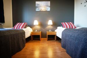 um quarto com duas camas e duas lâmpadas nas mesas em Grenivik Guesthouse em Grenivík