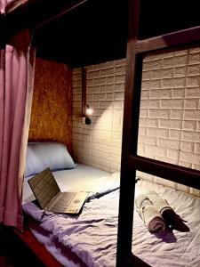a bedroom with a bunk bed with a laptop on it at Crew Bangkok Hostel in Bangkok
