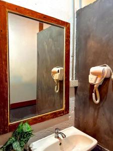 a bathroom with a sink with a mirror and a phone at Crew Bangkok Hostel in Bangkok +82 photos