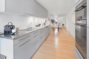 a kitchen with white cabinets and a wooden floor at BASEKAMP Prime I Friends I Lake I Mountains I Luzern in Küssnacht