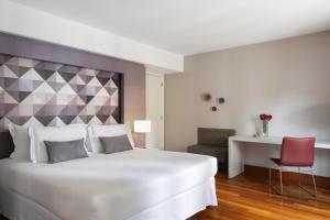 a bedroom with a large white bed and a red chair at NH Collection Curitiba in Curitiba +84 photos
