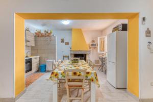 a kitchen with a table with chairs and a refrigerator at Casa Relax vicino a Otranto in Giurdignano +3 photos