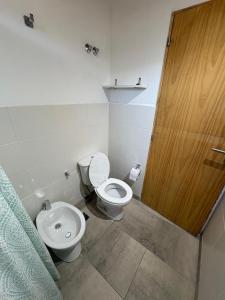 a bathroom with a toilet and a wooden door at Complejo Aiken in Trevelín