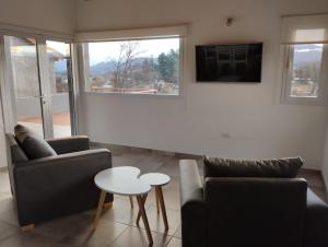 a living room with two couches and a table at Complejo Aiken in Trevelín +6 photos