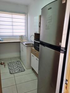 a kitchen with a refrigerator and a rug on the floor at Taltal - Cabañas in Taltal