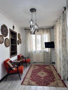 a living room with a couch and a tv at Dream Guest House in Bosteri