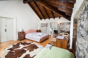 a bedroom with a bed and a desk in a room at Villa Pinetina B&B in Lasnigo