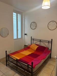 a bedroom with a bed with a colorful blanket at un lit double dans une chambre dans un appartement de 3 chambres en colocation à proximité du centre ville in Toulon