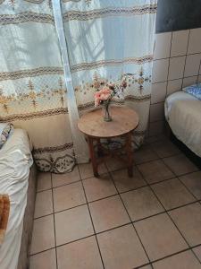 a small table with a vase of flowers on it at Potch Guest Home in Potchefstroom