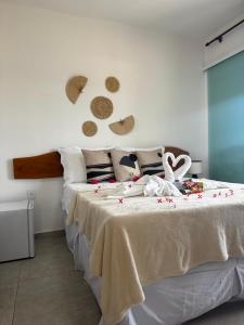 a bedroom with a large white bed with flowers on it at Pousada Vila Mar Japaratinga in Japaratinga +121 photos
