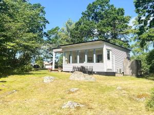 a small white house with windows on a yard at 6 person holiday home in SÖLVESBORG-By Traum in Sölvesborg +19 photos