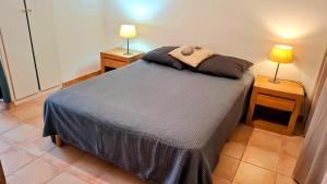a bedroom with a bed with two lamps on two tables at Résidence les Antillannes in Gourbeyre