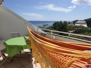 a hammock on a balcony overlooking the ocean at Résidence les Antillannes in Gourbeyre
