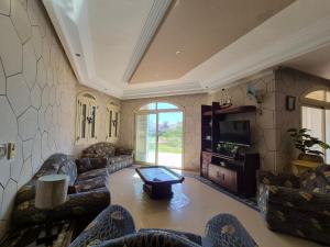 a large living room with couches and a table at Coastal Comforts at Casabianca in Dawwār Muḩammad Abū Shanab
