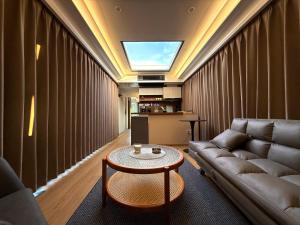 a living room with a couch and a table at Futuristic Capsule - Private Jacuzzi & Beach access in Wapnica