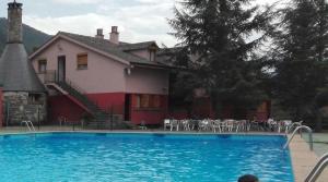 une grande piscine bleue en face d'une maison dans l'établissement Pinarillos, à Sarvisé