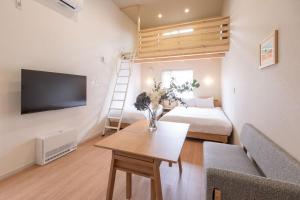 a living room with a couch a table and a tv at Yukari B in Asahikawa