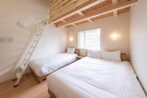 two beds in a room with a ladder at Yukari B in Asahikawa